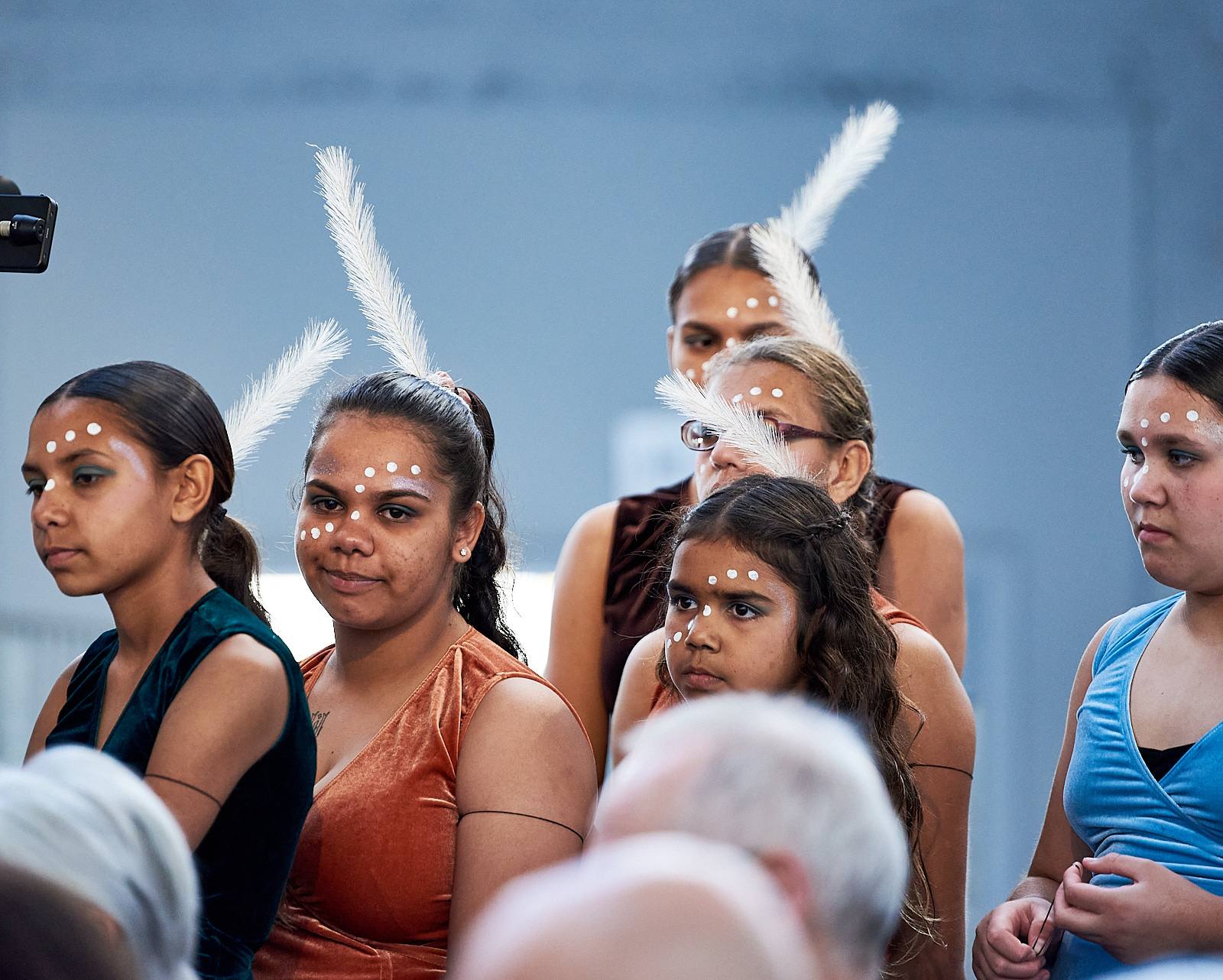 Aboriginal women and girl in cultural dress dancing on Country